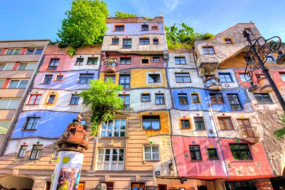 Un edificio di Vienna dal design unico e colorato, con finestre irregolari, sezioni dipinte in blu, rosa, giallo e bianco e verde sul tetto e sui balconi: una tappa obbligata se si visita l'Austria.